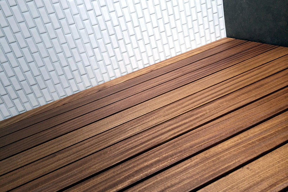 Réalisation d'un sauna champêtre en bois foncé de taille moyenne avec une baignoire d'angle, un carrelage blanc, mosaïque, un sol en bois brun, une vasque, un placard à porte plane, un plan de toilette en quartz modifié et un mur multicolore.