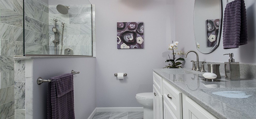 Klassisk inredning av ett litet badrum med dusch, med luckor med infälld panel, vita skåp, en hörndusch, en toalettstol med separat cisternkåpa, lila väggar, ett integrerad handfat, grått golv och med dusch som är öppen