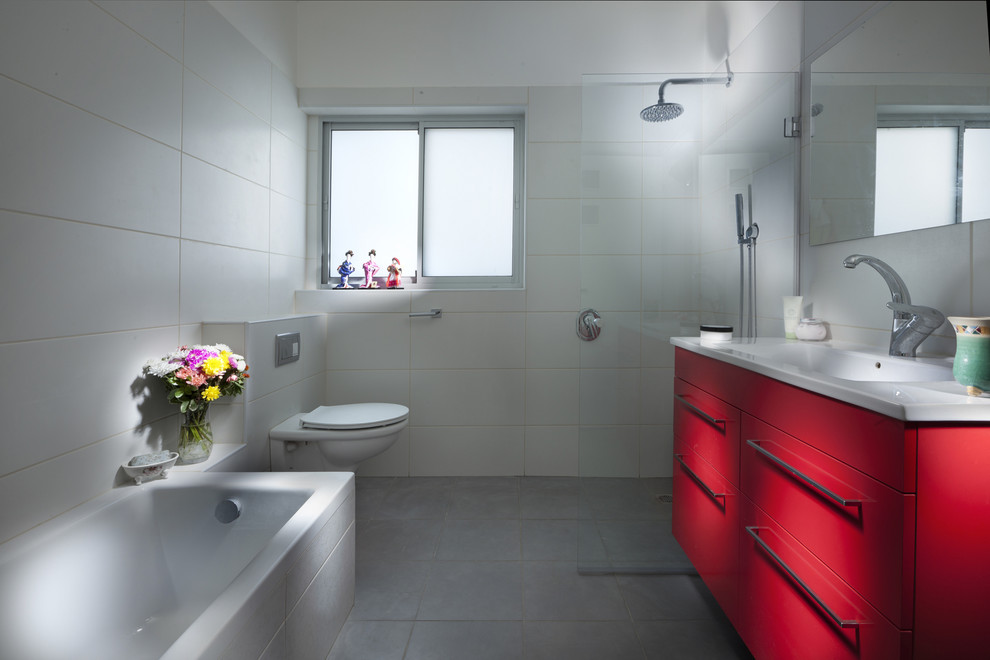 Exempel på ett modernt badrum, med en vägghängd toalettstol och röda skåp