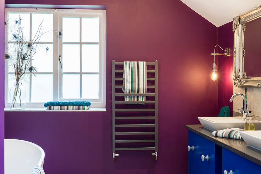 Foto på ett funkis grå en-suite badrum, med ett fristående badkar, våtrum, en toalettstol med hel cisternkåpa, grå kakel, cementkakel, lila väggar, cementgolv, bänkskiva i kvartsit och grått golv