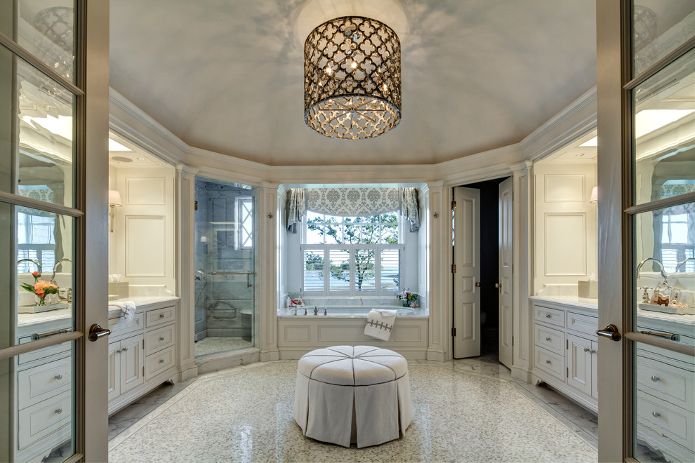 На фото: ванная комната в стиле неоклассика (современная классика) с фасадами с утопленной филенкой, белыми фасадами, открытым душем, унитазом-моноблоком, белой плиткой, белыми стенами, полом из керамической плитки, врезной раковиной, столешницей из гранита и полновстраиваемой ванной