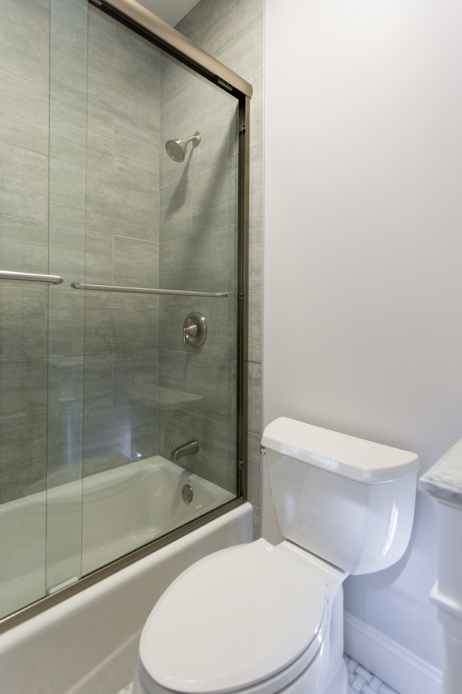 Foto på ett mellanstort vintage badrum med dusch, med luckor med profilerade fronter, vita skåp, ett badkar i en alkov, en dusch/badkar-kombination, en toalettstol med separat cisternkåpa, vit kakel, stenkakel, vita väggar, marmorgolv, ett undermonterad handfat och marmorbänkskiva