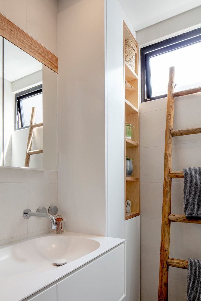 シドニーにあるコンテンポラリースタイルのおしゃれな浴室 (フラットパネル扉のキャビネット、白いキャビネット、白いタイル、白い壁、コンソール型シンク、白い洗面カウンター) の写真