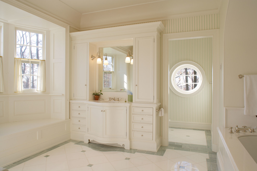Ejemplo de cuarto de baño clásico con lavabo bajoencimera, armarios con paneles lisos, puertas de armario blancas, encimera de mármol, bañera encastrada sin remate, baldosas y/o azulejos de piedra y baldosas y/o azulejos blancos
