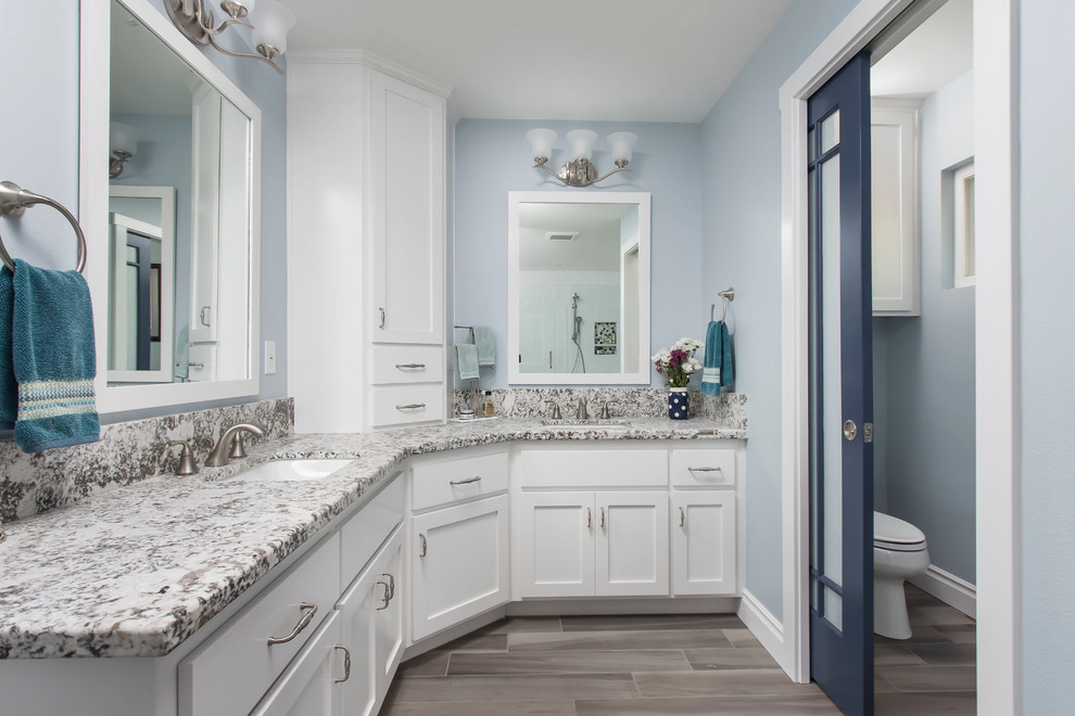Example of a large transitional master white tile and ceramic tile cement tile floor and gray floor bathroom design in Los Angeles with shaker cabinets, white cabinets, a two-piece toilet, blue walls, an undermount sink, granite countertops, a hinged shower door and gray countertops