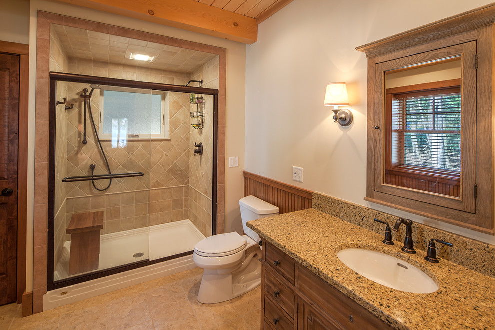 Foto di una stanza da bagno rustica con lavabo sottopiano, ante in legno scuro, doccia alcova, WC a due pezzi, piastrelle beige e pareti bianche