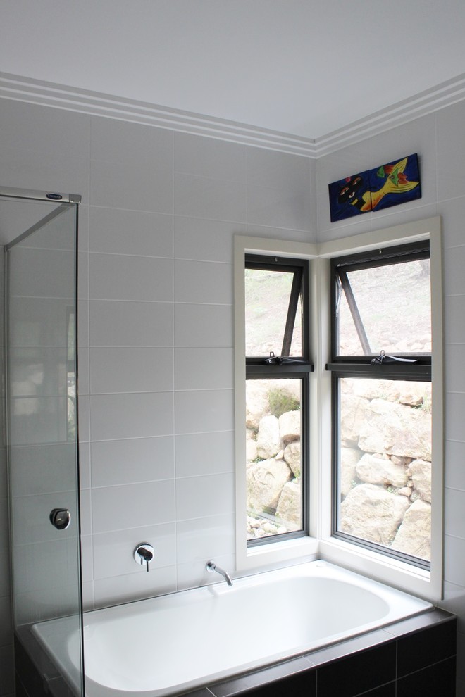 Foto på ett mellanstort funkis en-suite badrum, med ett piedestal handfat, släta luckor, granitbänkskiva, ett hörnbadkar, en hörndusch, vit kakel, porslinskakel, beige väggar och klinkergolv i porslin