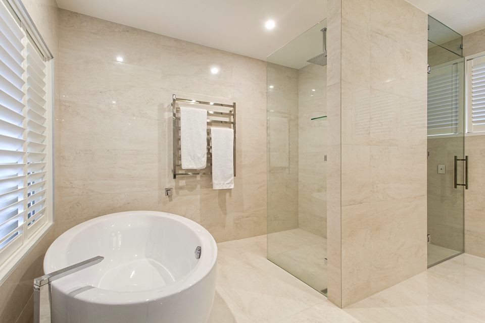 Photo of an expansive modern ensuite bathroom in Brisbane with a pedestal sink, recessed-panel cabinets, white cabinets, marble worktops, a freestanding bath, a corner shower, multi-coloured tiles, stone tiles and marble flooring.