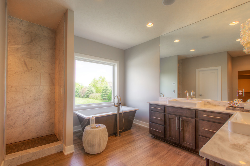 На фото: ванная комната в стиле неоклассика (современная классика) с отдельно стоящей ванной, двойным душем, светлым паркетным полом и монолитной раковиной