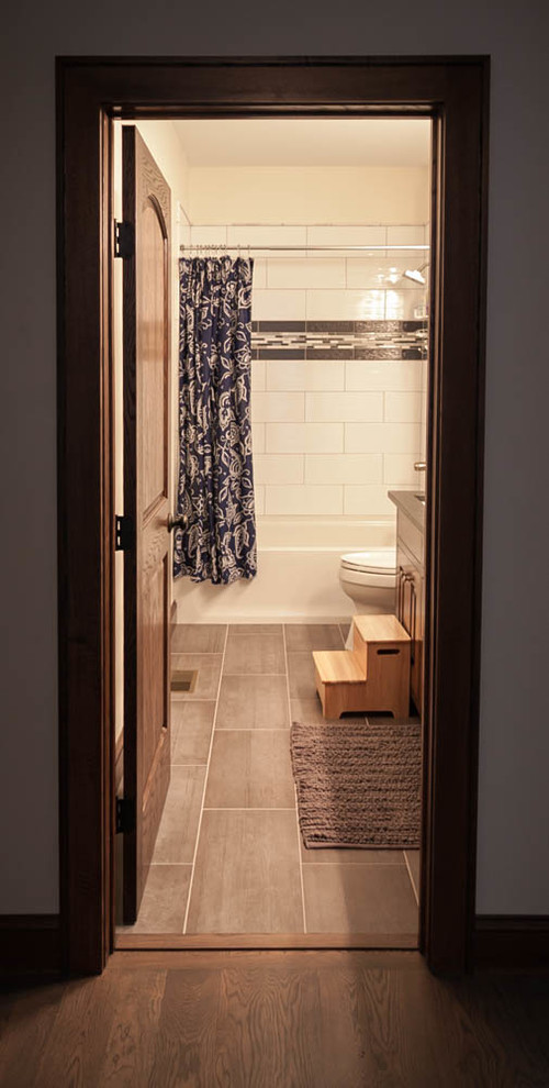 Стильный дизайн: ванная комната в классическом стиле с душем над ванной, унитазом-моноблоком, бежевыми стенами, полом из керамогранита и врезной раковиной - последний тренд