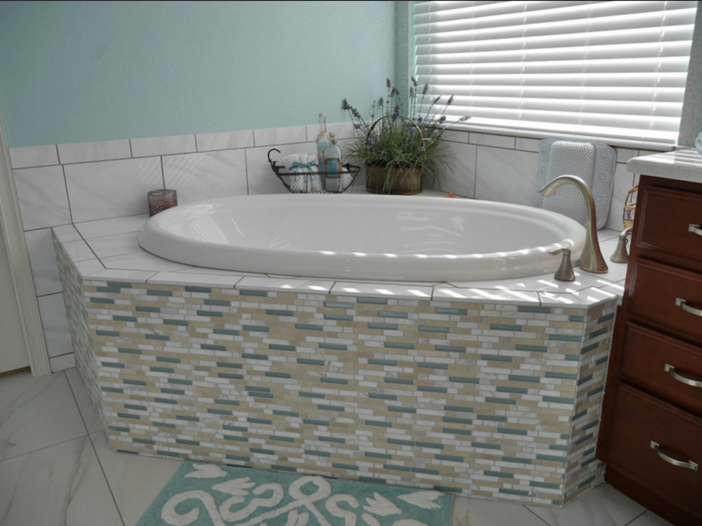 Modelo de cuarto de baño principal, marinero, grande, con armarios con paneles con relieve, puertas de armario de madera oscura, bañera esquinera, ducha empotrada, sanitario de dos piezas, baldosas y/o azulejos beige, baldosas y/o azulejos azules, baldosas y/o azulejos blancos, azulejos en listel, paredes azules, suelo de baldosas de cerámica, lavabo bajoencimera, encimera de cuarcita, suelo blanco, ducha abierta y encimeras blancas