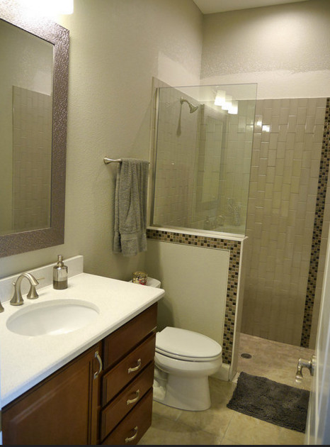 Photo of a medium sized beach style shower room bathroom in Tampa with raised-panel cabinets, medium wood cabinets, an alcove shower, a two-piece toilet, beige tiles, ceramic tiles, beige walls, ceramic flooring, a submerged sink, quartz worktops, beige floors, an open shower and white worktops.