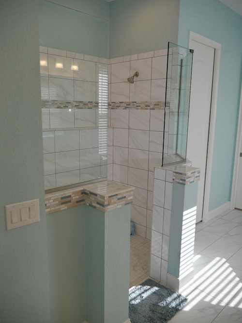 Idéer för att renovera ett stort maritimt vit vitt en-suite badrum, med luckor med upphöjd panel, skåp i mellenmörkt trä, ett hörnbadkar, en dusch i en alkov, en toalettstol med separat cisternkåpa, beige kakel, blå kakel, vit kakel, stickkakel, blå väggar, klinkergolv i keramik, ett undermonterad handfat, bänkskiva i kvartsit, vitt golv och med dusch som är öppen
