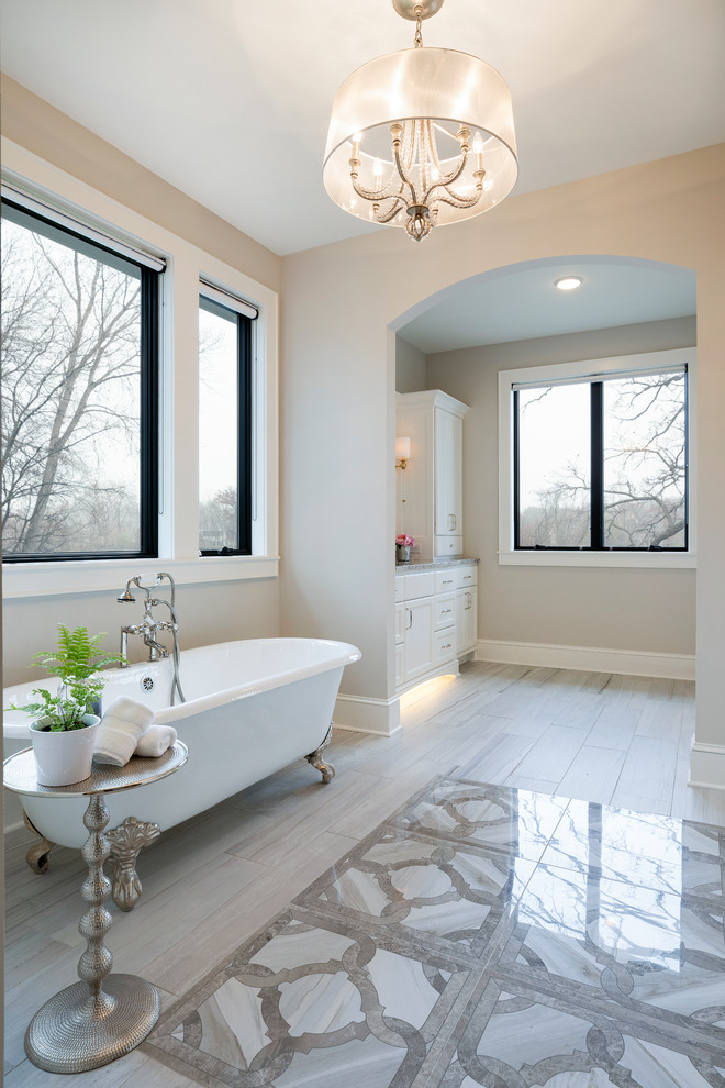 Badezimmer En Suite mit flächenbündigen Schrankfronten, weißen Schränken, Löwenfuß-Badewanne, Granit-Waschbecken/Waschtisch und grauer Waschtischplatte in Minneapolis