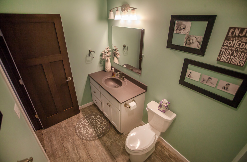 シーダーラピッズにある中くらいなトラディショナルスタイルのおしゃれなバスルーム (浴槽なし) (シェーカースタイル扉のキャビネット、白いキャビネット、分離型トイレ、一体型シンク、グレーの床、アルコーブ型浴槽、シャワー付き浴槽	、茶色いタイル、磁器タイル、緑の壁、磁器タイルの床、ラミネートカウンター、シャワーカーテン) の写真