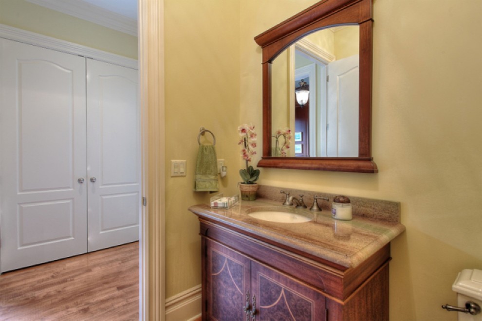 Idéer för att renovera ett mellanstort vintage badrum med dusch, med möbel-liknande, skåp i mellenmörkt trä, granitbänkskiva, gula väggar och ett undermonterad handfat
