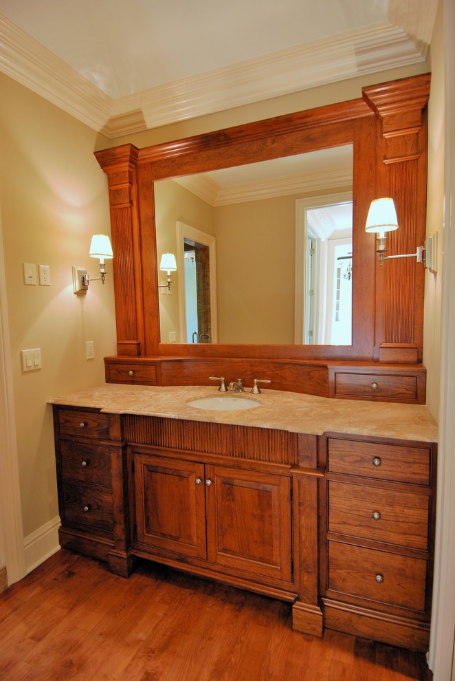 Photo of a medium sized traditional ensuite bathroom in New York with freestanding cabinets, medium wood cabinets, marble worktops, beige tiles, ceramic tiles, beige walls, medium hardwood flooring, a submerged sink and brown floors.