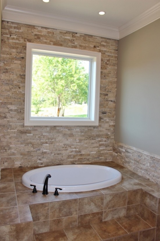 Modelo de cuarto de baño principal clásico grande con encimera de azulejos, bañera encastrada, sanitario de una pieza, baldosas y/o azulejos beige, paredes beige y suelo de baldosas de cerámica