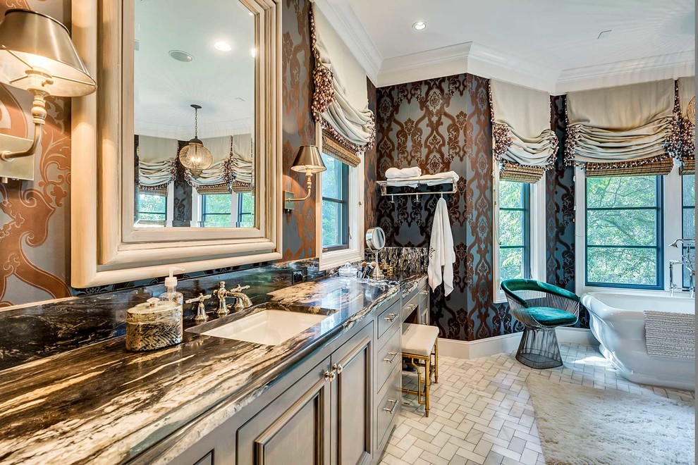 Inredning av ett klassiskt stort en-suite badrum, med luckor med infälld panel, grå skåp, ett fristående badkar, ett undermonterad handfat, marmorgolv och grått golv