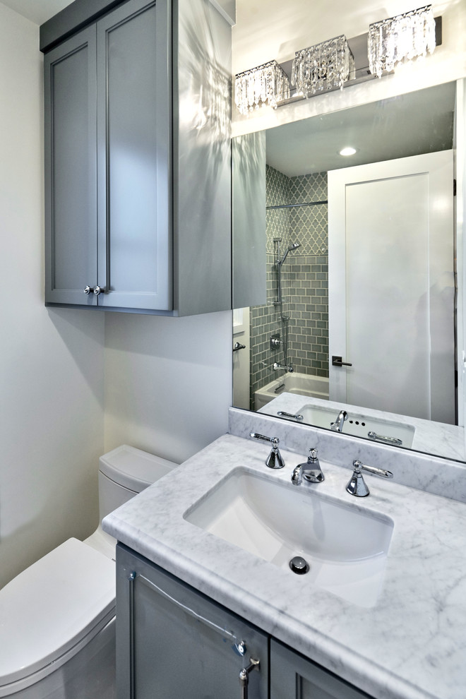 Example of a mid-sized transitional 3/4 gray tile and porcelain tile bathroom design in San Francisco with recessed-panel cabinets, gray cabinets, a two-piece toilet, gray walls, an undermount sink and marble countertops