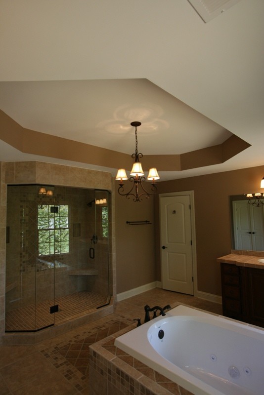 Rustik inredning av ett mellanstort en-suite badrum, med ett platsbyggt badkar, en dubbeldusch, grå kakel, keramikplattor, grå väggar, klinkergolv i porslin, ett nedsänkt handfat, kaklad bänkskiva, skåp i mörkt trä, luckor med upphöjd panel och beiget golv