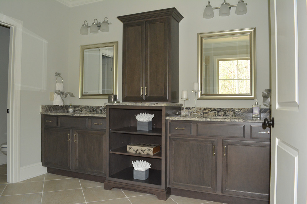 Esempio di una stanza da bagno padronale tradizionale di medie dimensioni con lavabo sottopiano, ante con bugna sagomata, ante grigie e top in granito