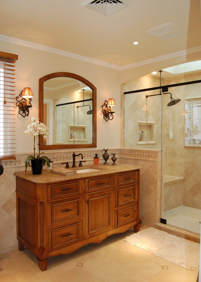Foto di una stanza da bagno classica con lavabo sottopiano, ante con riquadro incassato, ante in legno scuro, doccia alcova, piastrelle beige e piastrelle in travertino