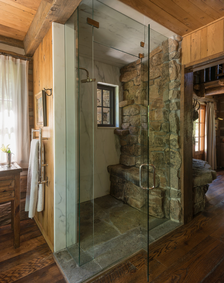 Rustikales Badezimmer mit bodengleicher Dusche, braunem Holzboden, Falttür-Duschabtrennung und Steinwänden in Philadelphia
