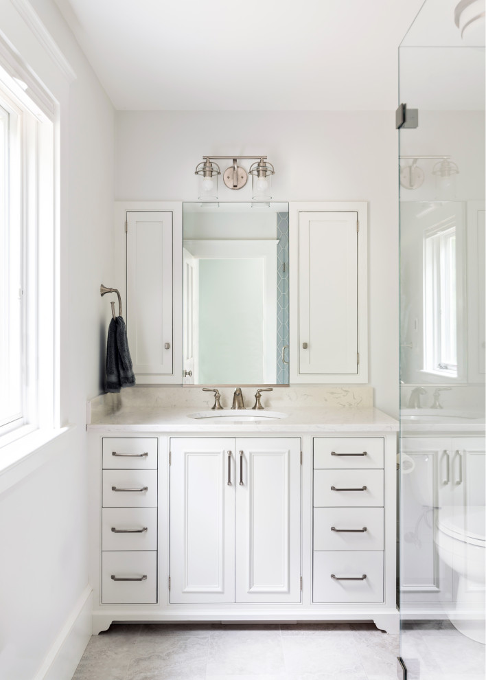 Inspiration för ett mellanstort vintage vit vitt badrum med dusch, med luckor med infälld panel, vita skåp, en hörndusch, vita väggar, klinkergolv i porslin, ett undermonterad handfat och grått golv