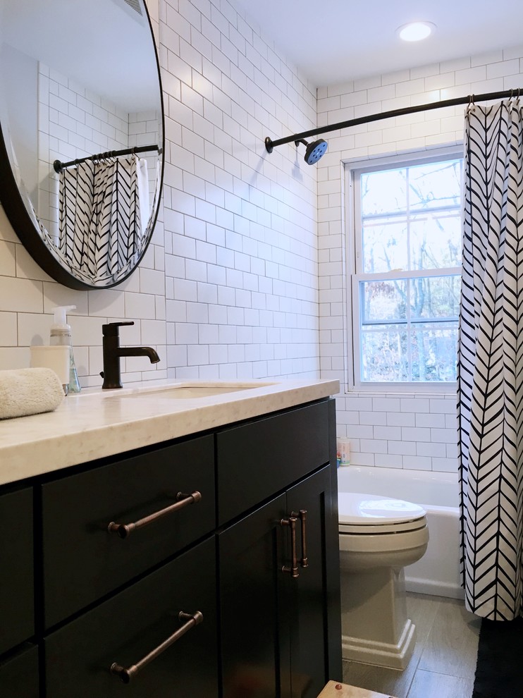This is an example of a medium sized classic family bathroom in New York with shaker cabinets, blue cabinets, an alcove bath, a shower/bath combination, a two-piece toilet, white tiles, metro tiles, grey walls, ceramic flooring, a submerged sink and engineered stone worktops.