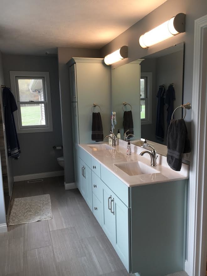 Imagen de cuarto de baño clásico renovado con armarios con paneles empotrados, puertas de armario azules, paredes grises, suelo laminado, lavabo encastrado y encimera de cuarcita