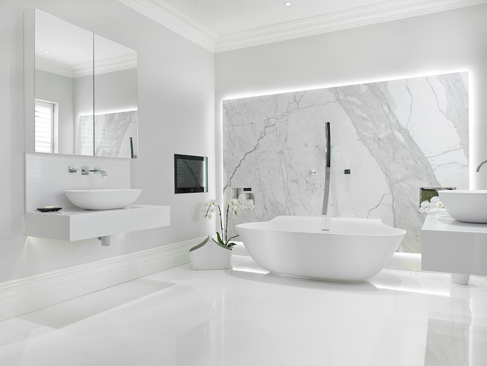 Inspiration pour une grande salle de bain principale design avec une baignoire indépendante, un carrelage blanc, du carrelage en marbre, un mur blanc, un sol en carrelage de porcelaine, une vasque, un plan de toilette en surface solide, un sol blanc et un plan de toilette blanc.