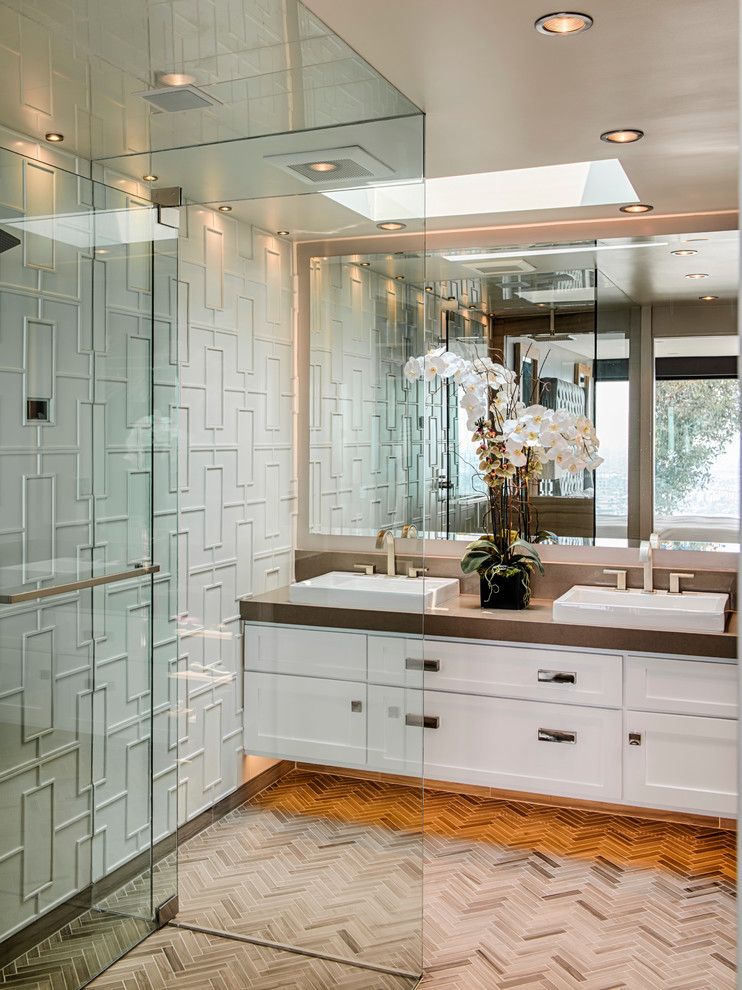 Contemporary bathroom in Los Angeles with shaker cabinets, white cabinets, a corner shower and white tiles.