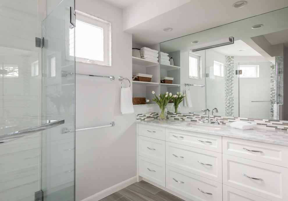 Medium sized traditional shower room bathroom in Boston with recessed-panel cabinets, white cabinets, a corner shower, grey tiles, porcelain tiles, grey walls, porcelain flooring, a submerged sink, marble worktops, brown floors and a hinged door.