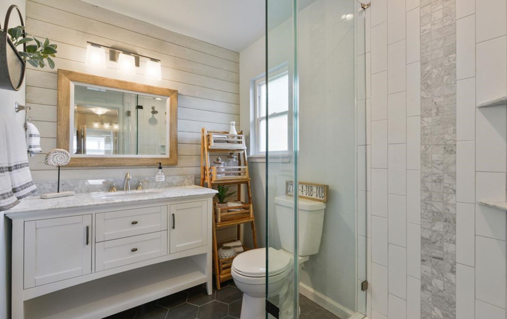 Photo of a country shower room bathroom in San Francisco with shaker cabinets, white cabinets, an alcove shower, a two-piece toilet, white tiles, ceramic tiles, grey walls, ceramic flooring, a submerged sink, black floors and grey worktops.