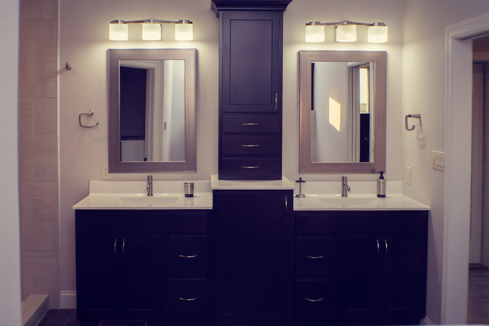 Idée de décoration pour une grande salle de bain principale minimaliste avec un placard à porte plane, des portes de placard noires, une baignoire indépendante, un mur beige, un sol en carrelage de céramique, un lavabo posé et un plan de toilette en granite.