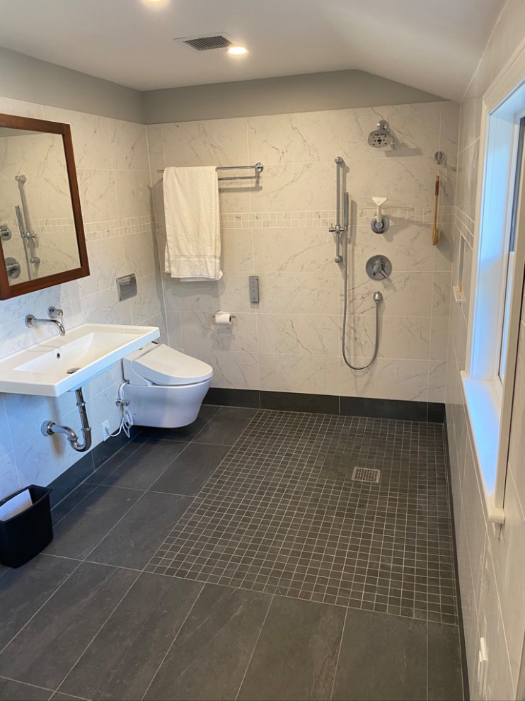 Design ideas for a small contemporary ensuite bathroom in Boston with a built-in shower, a wall mounted toilet, white tiles, porcelain tiles, grey walls, porcelain flooring, a wall-mounted sink, grey floors, an open shower, a wall niche, a single sink and a floating vanity unit.