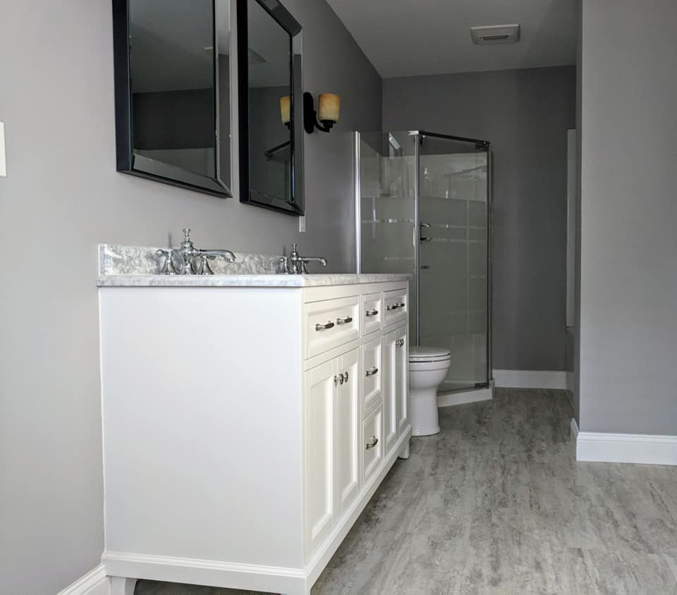 Exempel på ett klassiskt grå grått badrum, med möbel-liknande, vita skåp, en hörndusch, en toalettstol med hel cisternkåpa, grå väggar, vinylgolv, ett undermonterad handfat, marmorbänkskiva, grått golv och dusch med gångjärnsdörr