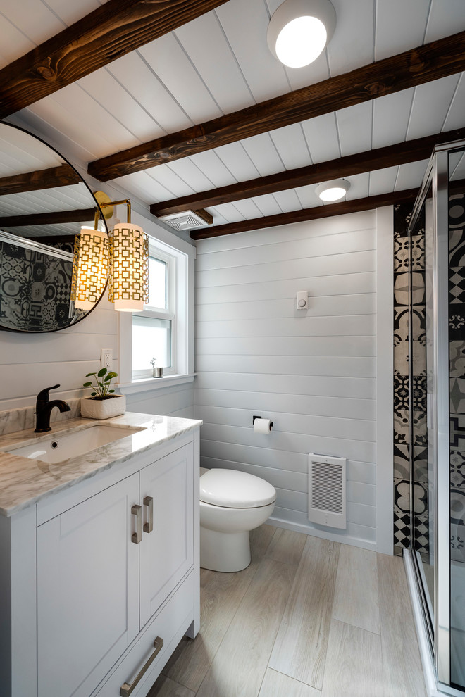 Modelo de cuarto de baño clásico renovado con armarios con paneles empotrados, puertas de armario blancas, ducha esquinera, paredes blancas, lavabo bajoencimera, suelo beige y encimeras beige