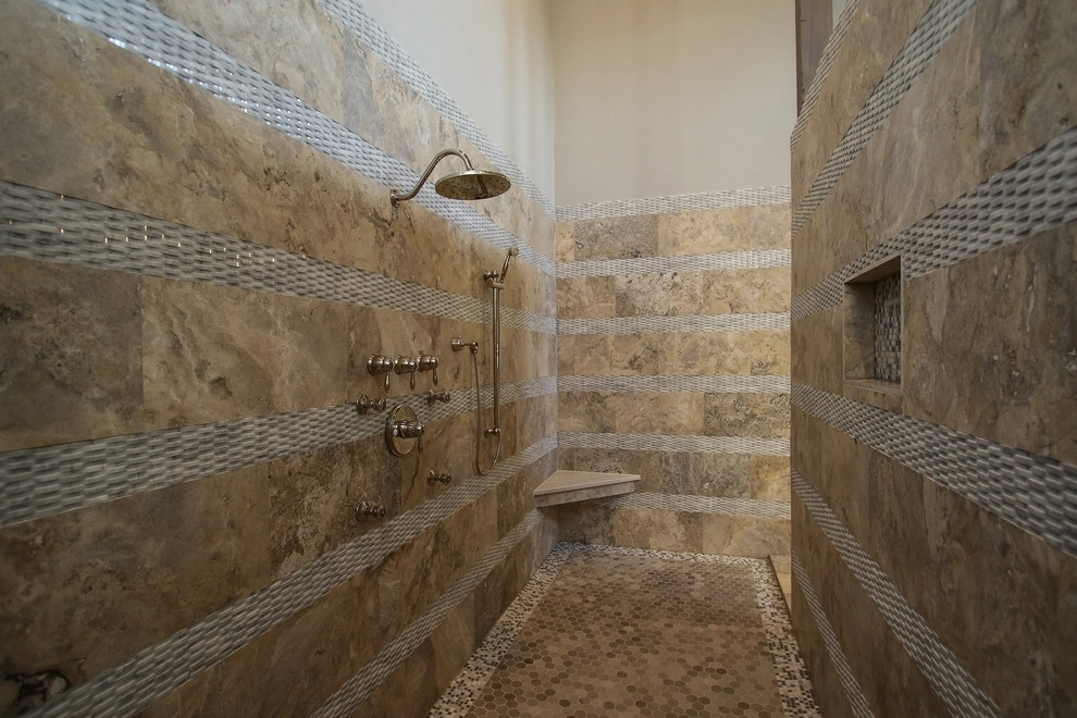 На фото: огромная главная ванная комната в классическом стиле с фасадами с выступающей филенкой, темными деревянными фасадами, отдельно стоящей ванной, открытым душем, унитазом-моноблоком, бежевой плиткой, каменной плиткой, серыми стенами, полом из травертина, накладной раковиной и мраморной столешницей с