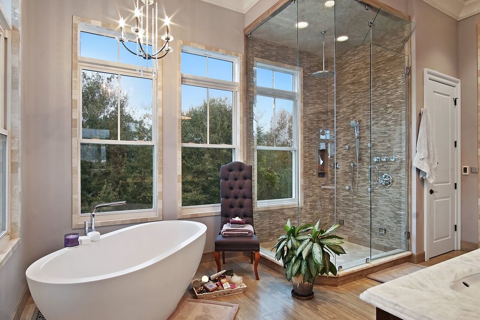 Exempel på ett mellanstort klassiskt beige beige en-suite badrum, med ett fristående badkar, en hörndusch, beige kakel, stickkakel, beige väggar, mellanmörkt trägolv, ett undermonterad handfat, marmorbänkskiva, brunt golv och dusch med gångjärnsdörr