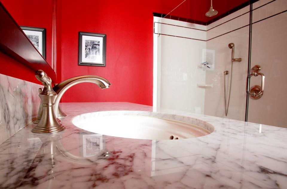Inspiration för moderna badrum för barn, med ett undermonterad handfat, marmorbänkskiva, en dusch/badkar-kombination, vit kakel, keramikplattor och röda väggar