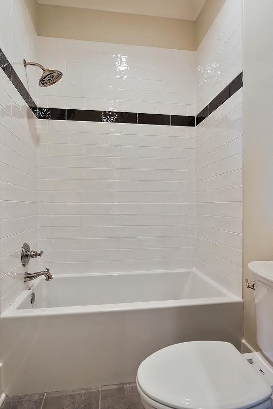 Diseño de cuarto de baño clásico renovado de tamaño medio con armarios con paneles con relieve, puertas de armario blancas, combinación de ducha y bañera, baldosas y/o azulejos de cerámica, paredes blancas y lavabo bajoencimera