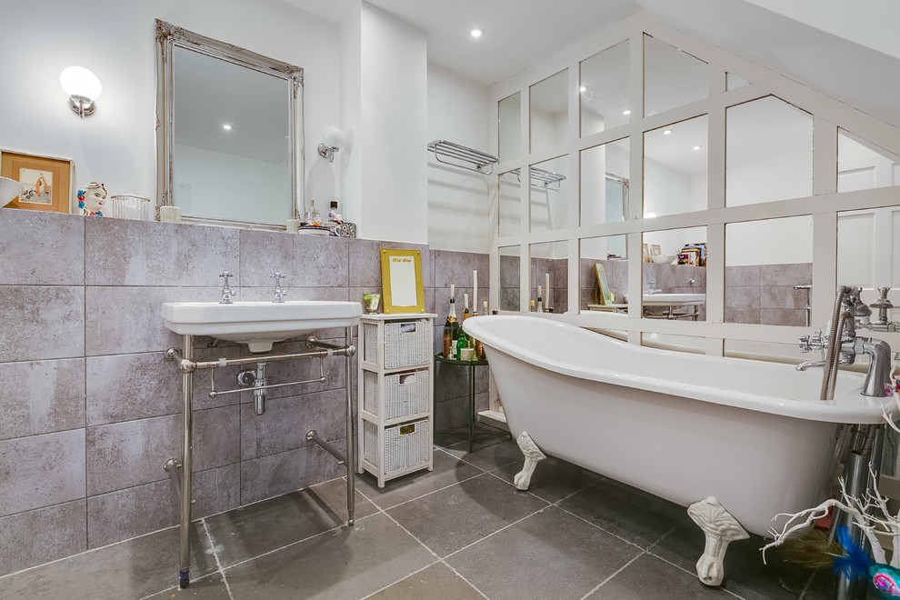 Photo of a small classic bathroom in London with a claw-foot bath, grey tiles, grey walls, a console sink and grey floors.