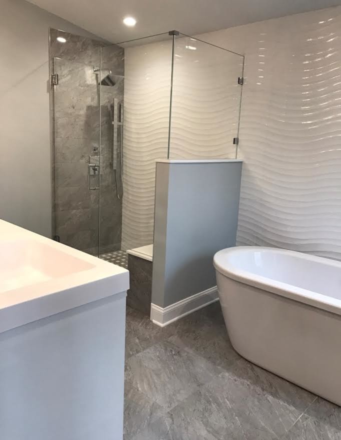 Medium sized traditional ensuite bathroom in New York with a freestanding bath, a corner shower, white tiles, grey walls, marble flooring, an integrated sink, grey floors, a hinged door and white worktops.