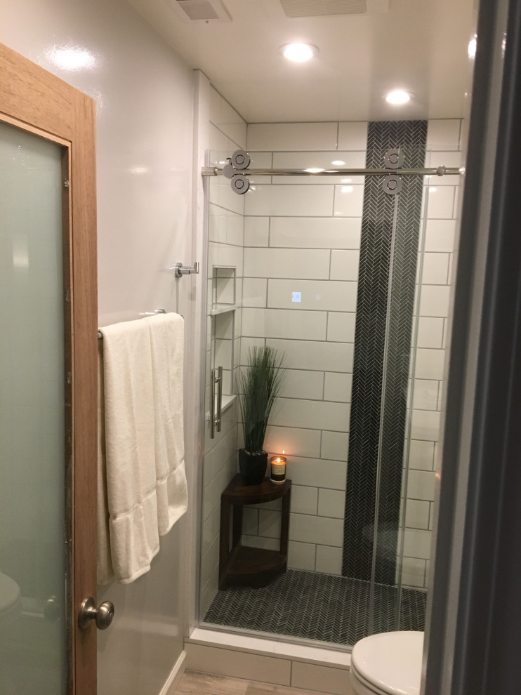 Exemple d'une salle de bain moderne de taille moyenne avec un placard avec porte à panneau encastré, des portes de placard grises, WC séparés, un mur gris, sol en stratifié, un lavabo encastré, un plan de toilette en quartz, un sol marron, une cabine de douche à porte coulissante et un plan de toilette blanc.