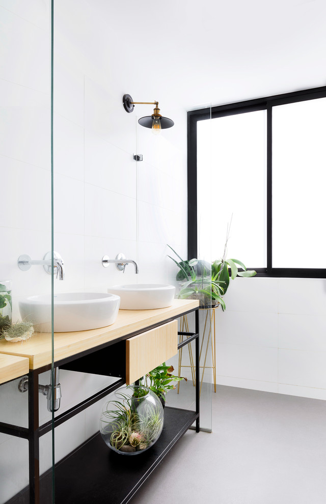 Foto de cuarto de baño actual con puertas de armario de madera clara, baldosas y/o azulejos blancos, paredes blancas, aseo y ducha, lavabo sobreencimera, encimera de madera, suelo gris, encimeras beige y armarios con paneles lisos