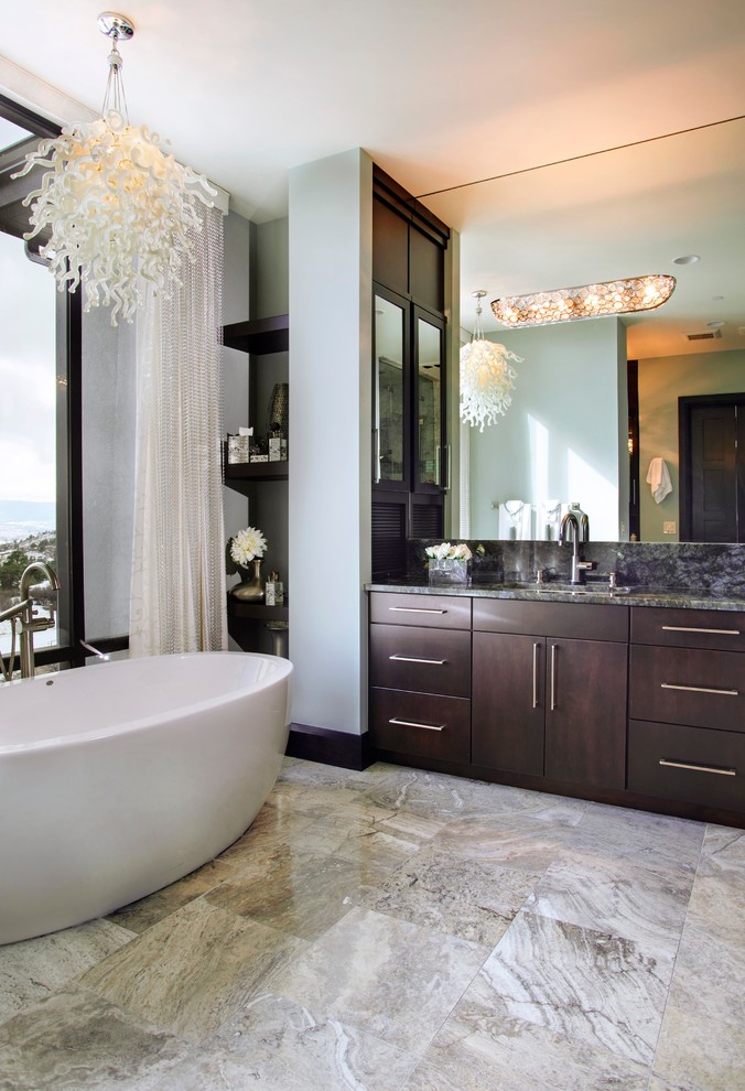 На фото: главная ванная комната среднего размера в современном стиле с плоскими фасадами, темными деревянными фасадами, отдельно стоящей ванной, серыми стенами, полом из керамогранита, врезной раковиной и бежевым полом