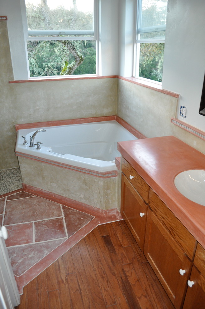 Klassisches Badezimmer mit Whirlpool, Toilette mit Aufsatzspülkasten, orangen Fliesen, verzierten Schränken, hellen Holzschränken und weißer Wandfarbe in San Luis Obispo