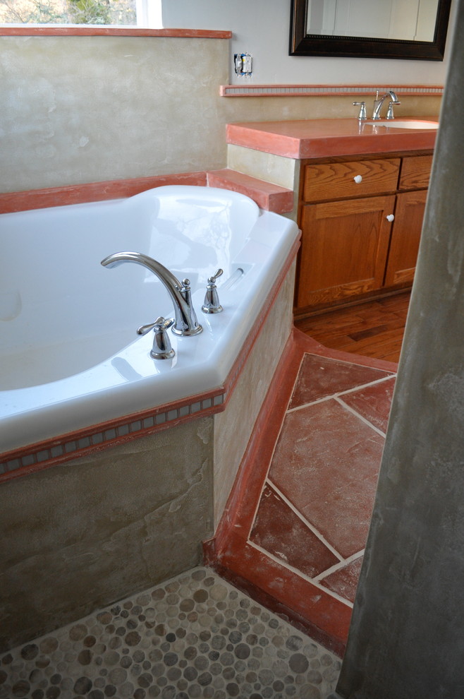 Réalisation d'une salle de bain tradition en bois clair avec un bain bouillonnant, WC à poser, un carrelage orange et un placard en trompe-l'oeil.